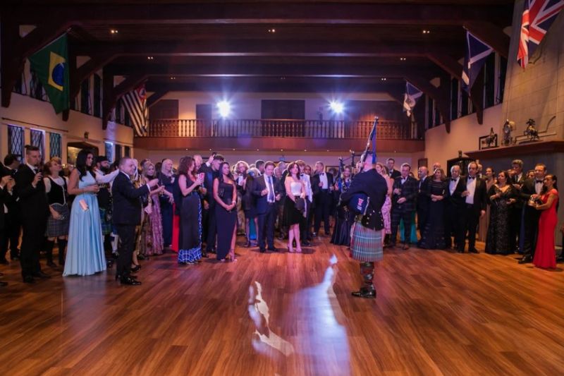 Crowd of people listening to a piper at St Andrew Society of São Paulo