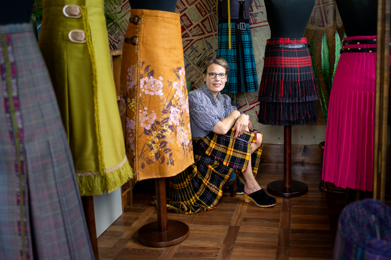 Scottish kiltmaker ACME Atelier surrounded by modern Scottish kilts