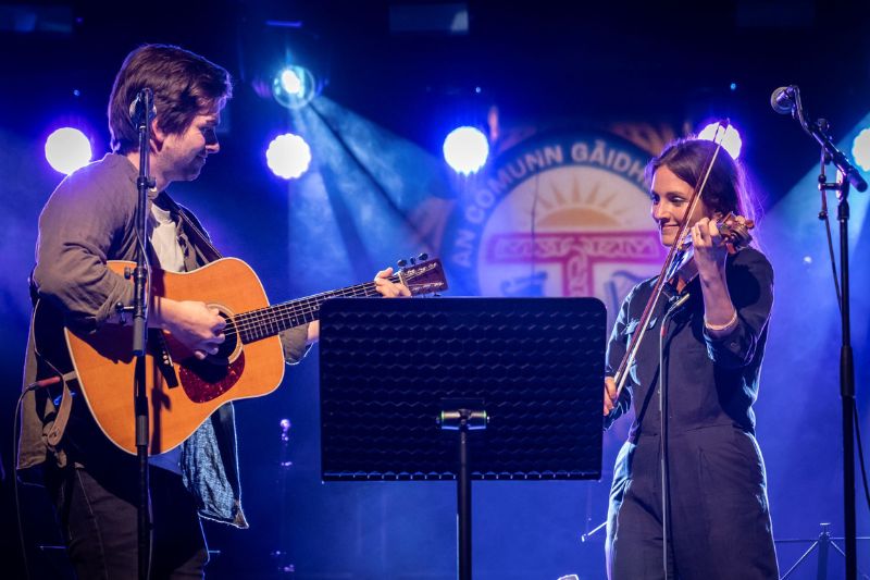 Two people playing instruments at the Ar Cànan ’s Ar Ceòl concert at the Royal National Mòd